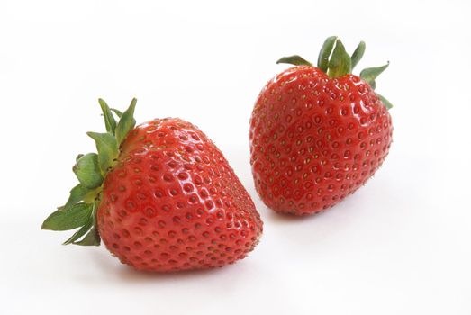 A couple of ripe red strawberries on white background.