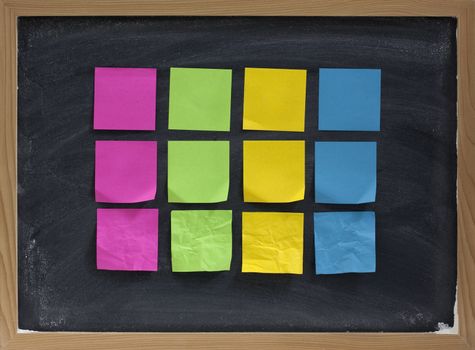 blank, colorful, smooth and crumpled, sticky notes on blackboard with white chalk smudges