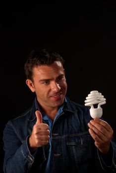 Attractive guy giving thumbs up to engergy saving bulb