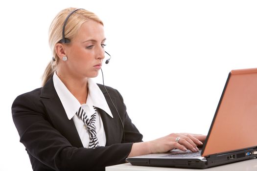 Pretty blond business woman with headphone behind her laptop