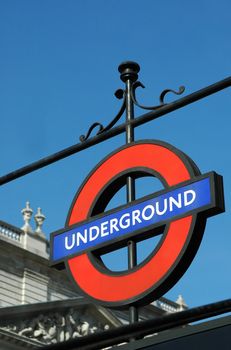 underground travel sign against a clear blue sky