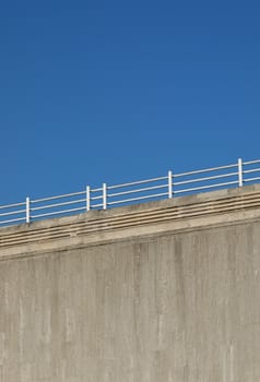 concrete wall and railings against a blue sky