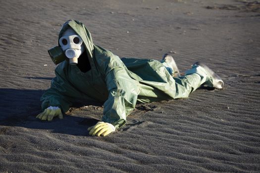 Man in gas-mask crawling through the desert land