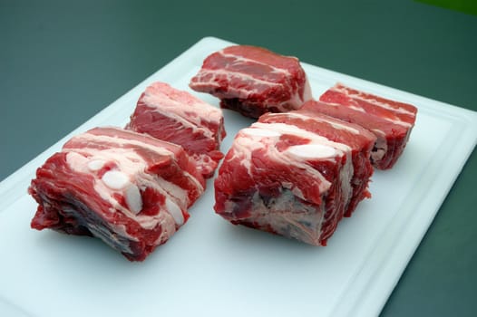 raw meat pieces on a white cutting board