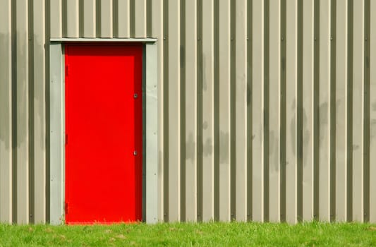 red fire exit doorway on a warehouse exterior