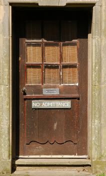 no admittance sign on a battered old door