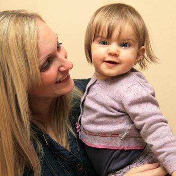 Happy, smiling mother with her baby in her arms. Even the baby laughs
