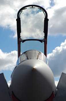 jet fighter canopy silhouette against a blue cloudy sky