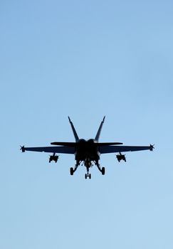 fighter jet silhouette against blue sky
