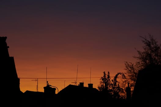Abstract shot od the sunset, roofs with antennas
