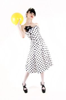 Portrait of a young beautiful brunette posing with yellow ball