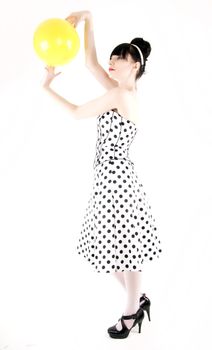 Portrait of a young beautiful brunette posing with yellow ball