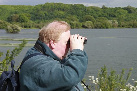man with his binoculars looking out for birds 