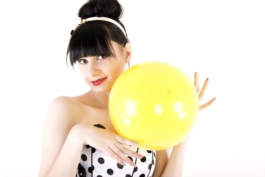 Portrait of a young beautiful brunette posing with yellow ball