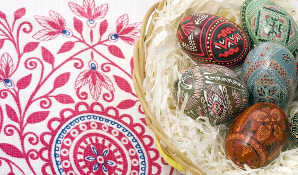 ornamented Easter eggs in bin on tablecloth