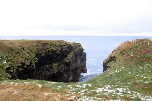 winters snow on the ballybunion cliffside walk with cliff face
