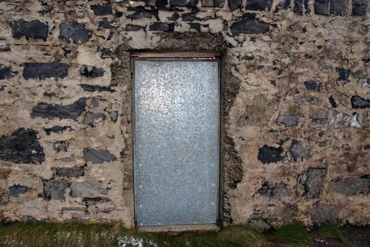 steel door in an old stone wall in kerry ireland