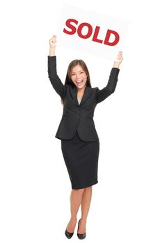 Realtor showing sold sign happy and excited. Smiling joyful Asian / Caucasian real estate agent woman celebrating a house sale. Isolated on white background standing in full length