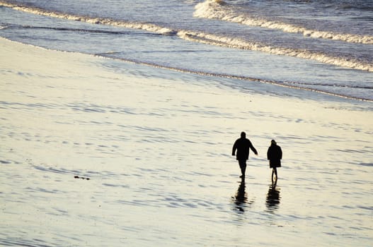Shot of adult couple walking on the beach of Saint-Malo in brittany, france