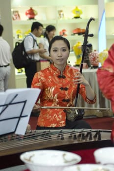 CHINA, GUANGDONG, SHENZHEN - MAY 16, 2009: China Culture Exhibition, showing Chinese art, traditions, folk music, costumes, modern art, opera, different minorities. Photo presents Chinese girls, musicians playing traditional instruments.