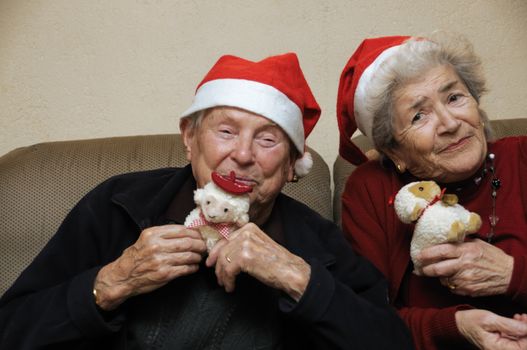 Old senior couple with santa hats celebrating christmas