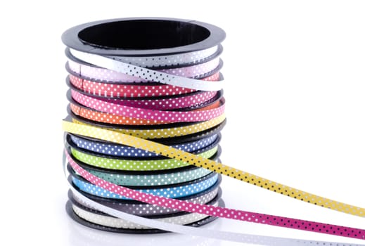 Decoration ribbon on a roll; in different colors on a white background.