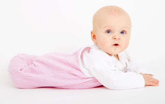infant girl lying on a white background
