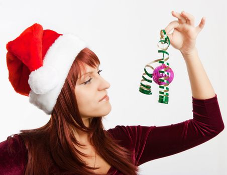 girl in a Christmas hat holding a New Year's ball
