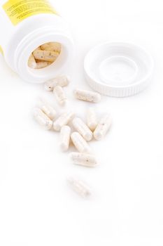 Some capsuls with bottle on white background