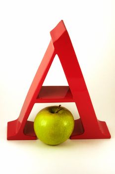 A bright red capital letter A is represented in the alphabet by a green Granny Smith apple.