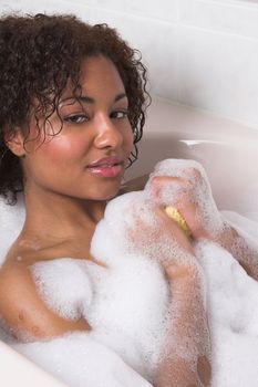 Beautiful woman having a bath with bubbles
