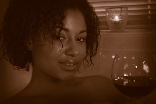 Beautiful woman enjoying her wine in bath