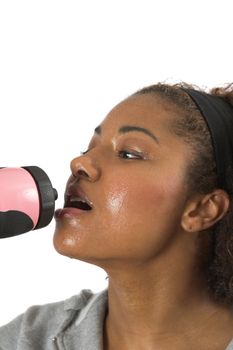 Woman with sweaty face having a refreshing drink after her workout