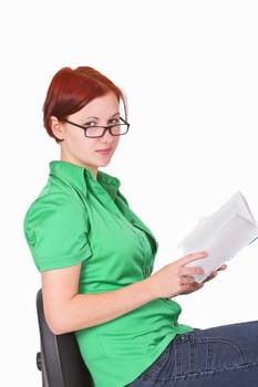 Close-up image of a young redheaded teenager with a book in her hands.