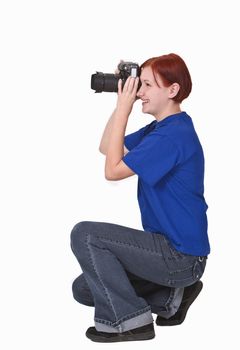 Redheaded girl taking photos with a DSRL camera.