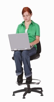 Redheaded teenager sitting on a high chair and working on alpatop.Shot with Canon 70-200mm f/2.8L IS USM