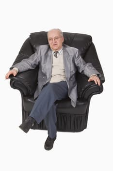 Image of a senior speaking while he is sitting relaxed in an armchair-upper view.