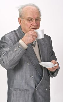 Senior man drinking tea from a cup.Shot with Canon 70-200mm f/2.8L IS USM