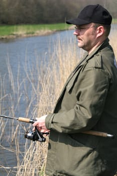 Fisherman standing by the waterside