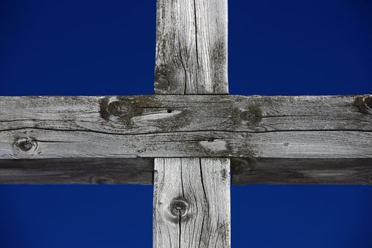 Part of a weathered wood cross on blue sky 


