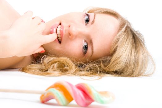 Young blond woman tempted by a lollipop