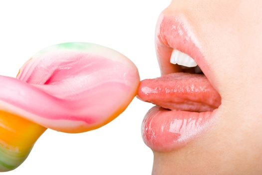 Close-up of a young woman's tongue licking candy