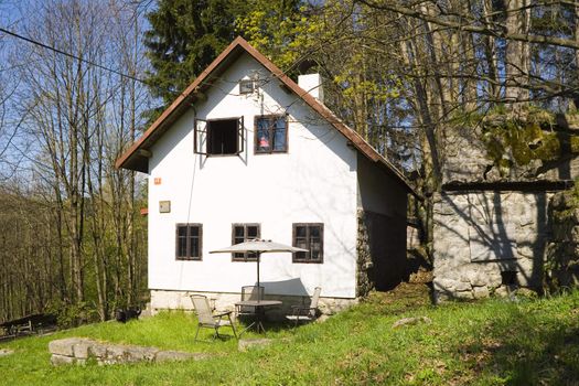 a little white house on a mountain meadow among woods