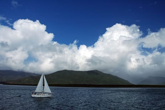 white boat travelling near Cairns, white clouds in distance