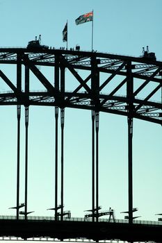 detail photo of harbour bridge in sydney, australian flag, people on top 