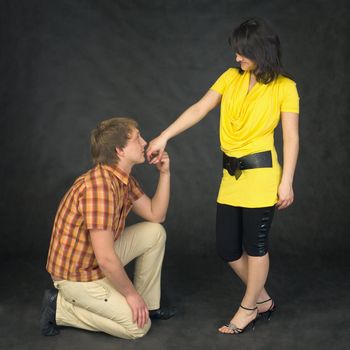 Man kisses a hand to the woman kneeling