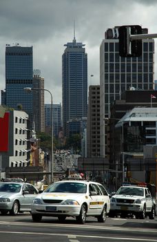 city traffic in sydney, taxi and police car in front, skyscrapers in background