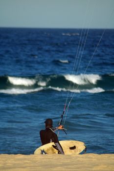 Kite surfer going into water, blurred ocean in background, photo taken in Sydney, 