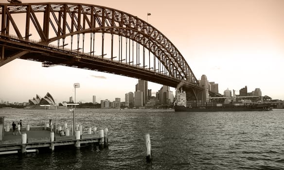black and white colored photograph of sydney; harbour bridge, opera house and sydney CBD, photo taken from north sydney
