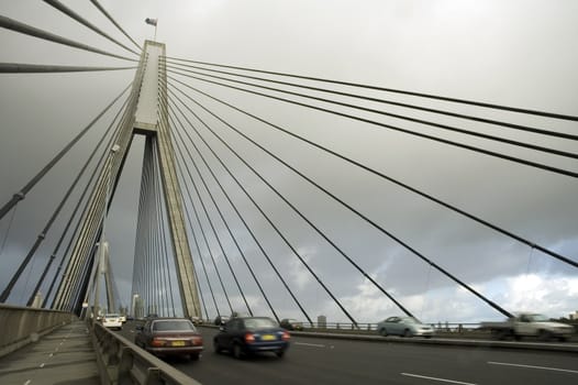 anzac bridge in sydney, cars in motion, cloudy sky